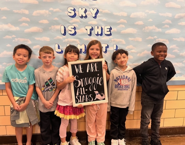 6 Snug Harbor students pose with a sign that reads "We Are Snuggie All-Stars"