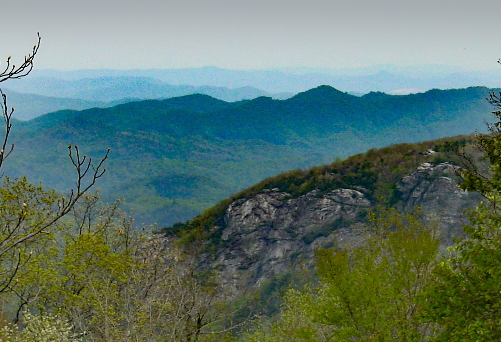 A rocky outcropping is evident in the mid ground with mountains to the horizon. 