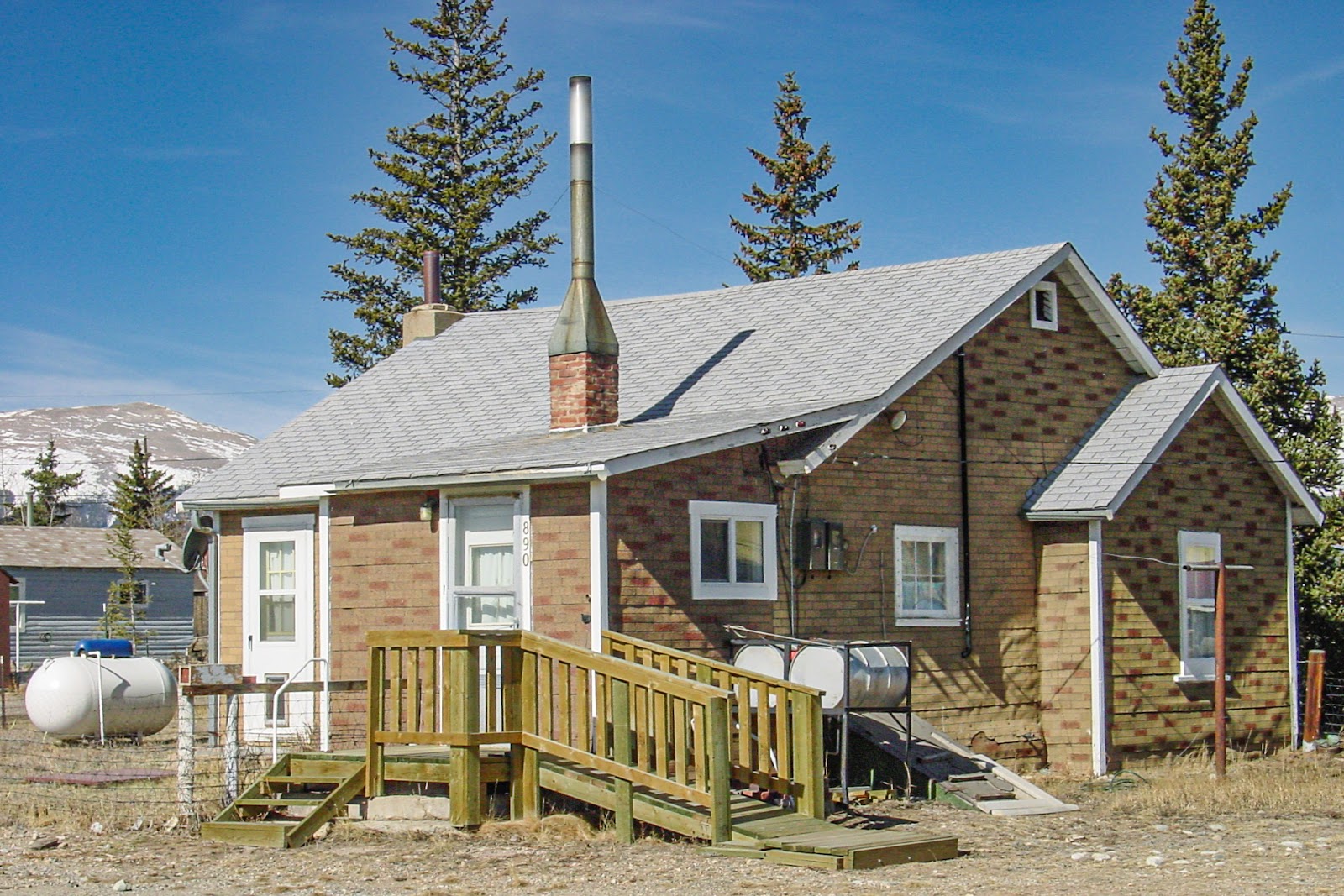 A one-story home with wooden ramp