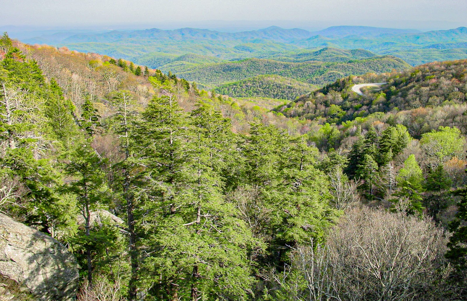 The scene looks down into a mountain valley with a road snaking up on the right. 