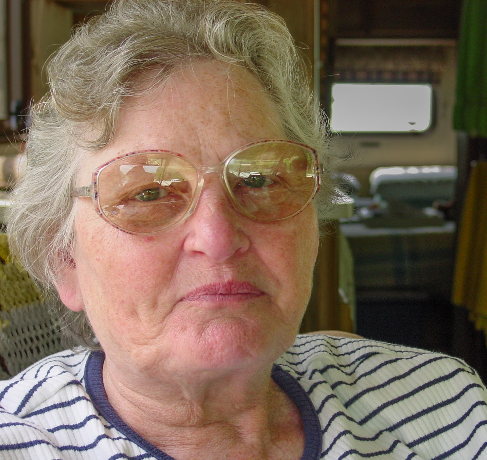 Woman with glasses purses her lips. 