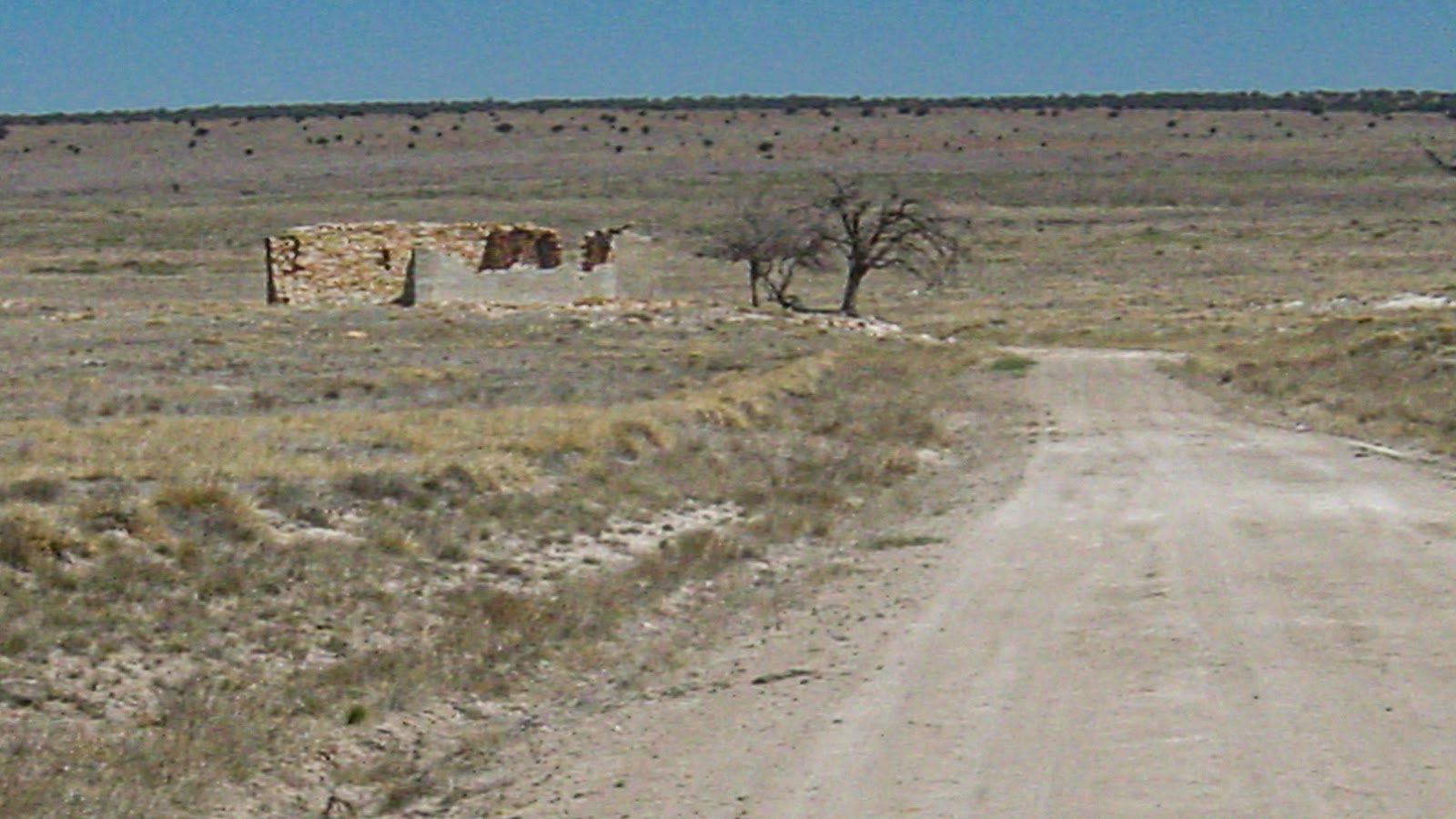 An adobe brick structure with no roof in arid desert. 