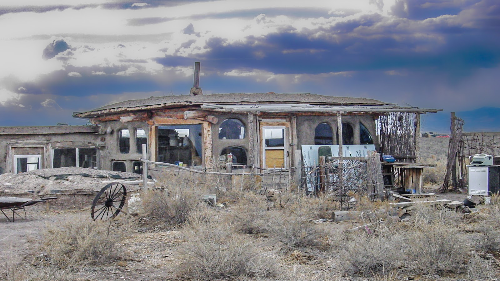 An adobe home with several windows against a dark sky. 