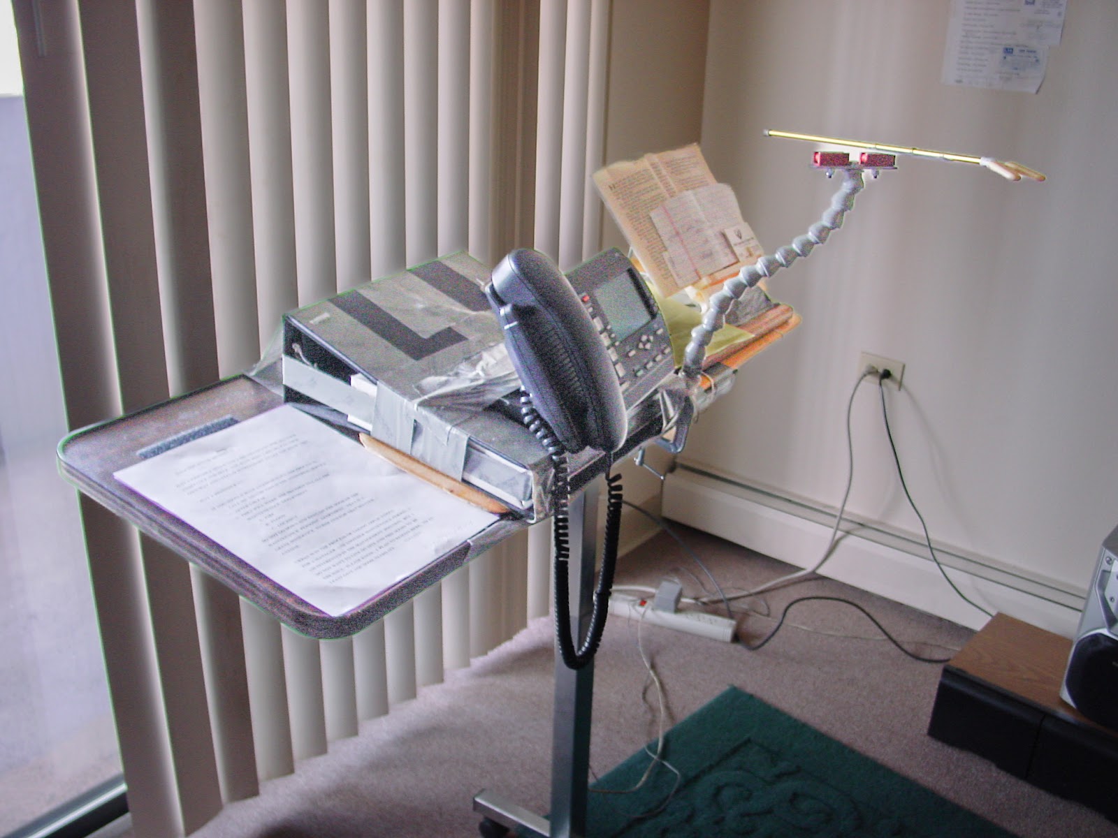 A portable table with phone and accessories for a mouth stick.