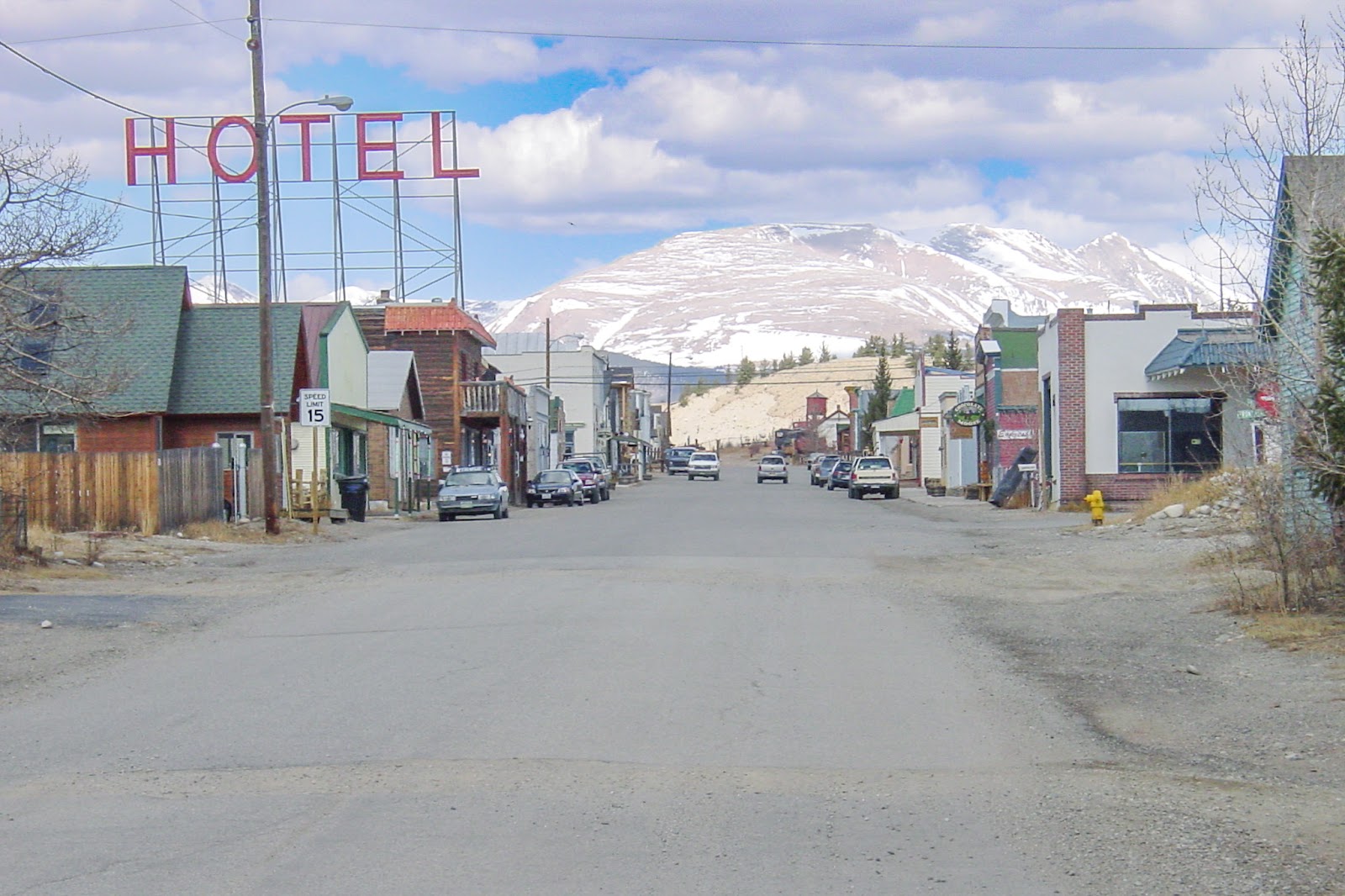 Wide paved road in a small town, HOTEL sign in light blue sky