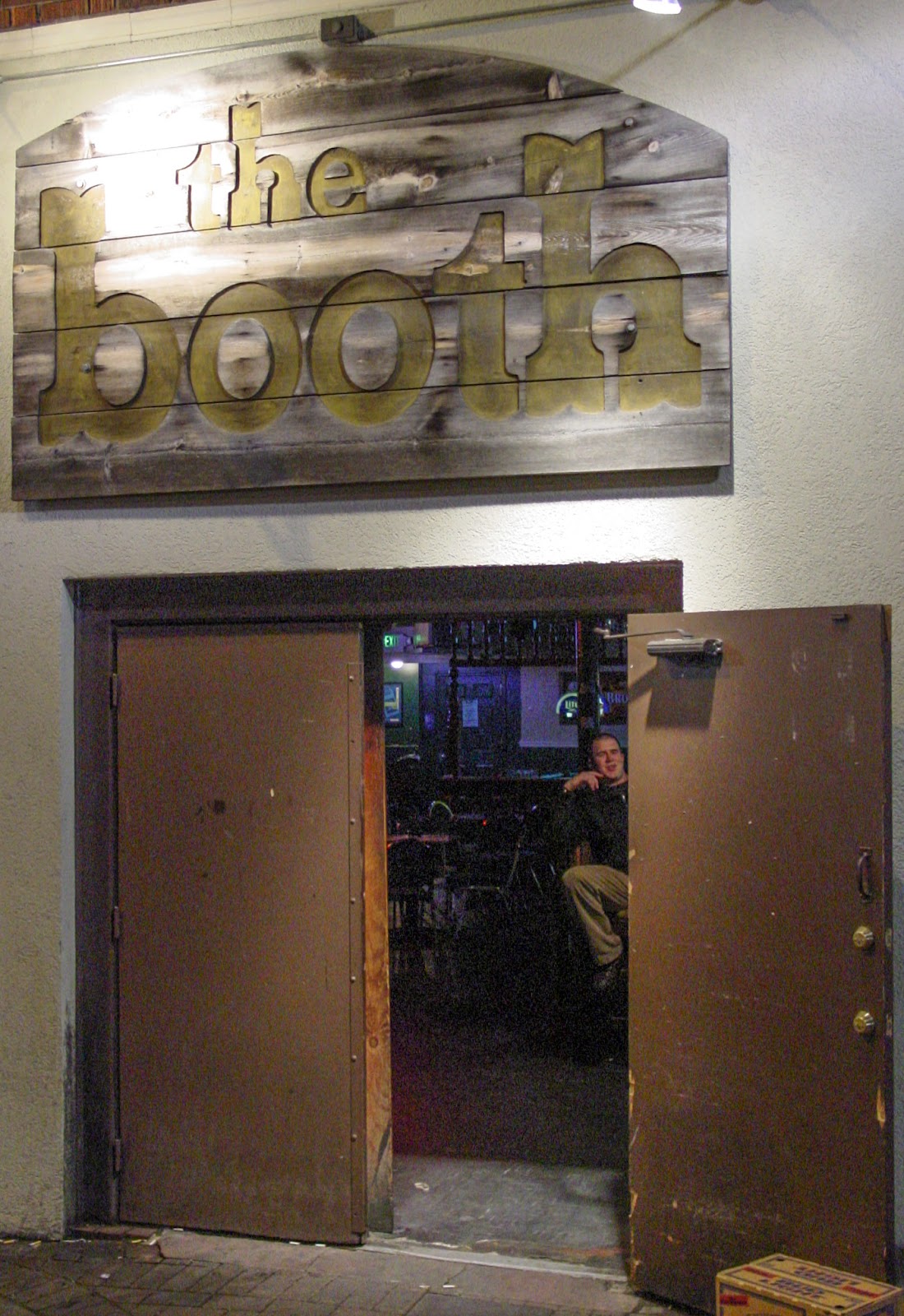 A tavern open door with sign above that says: The Booth