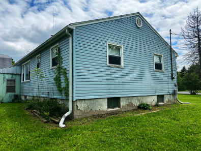 Back and side of 136 Searles Rd. Shows Dining Room window, bathroom window, bedroom windows and basement windows. 