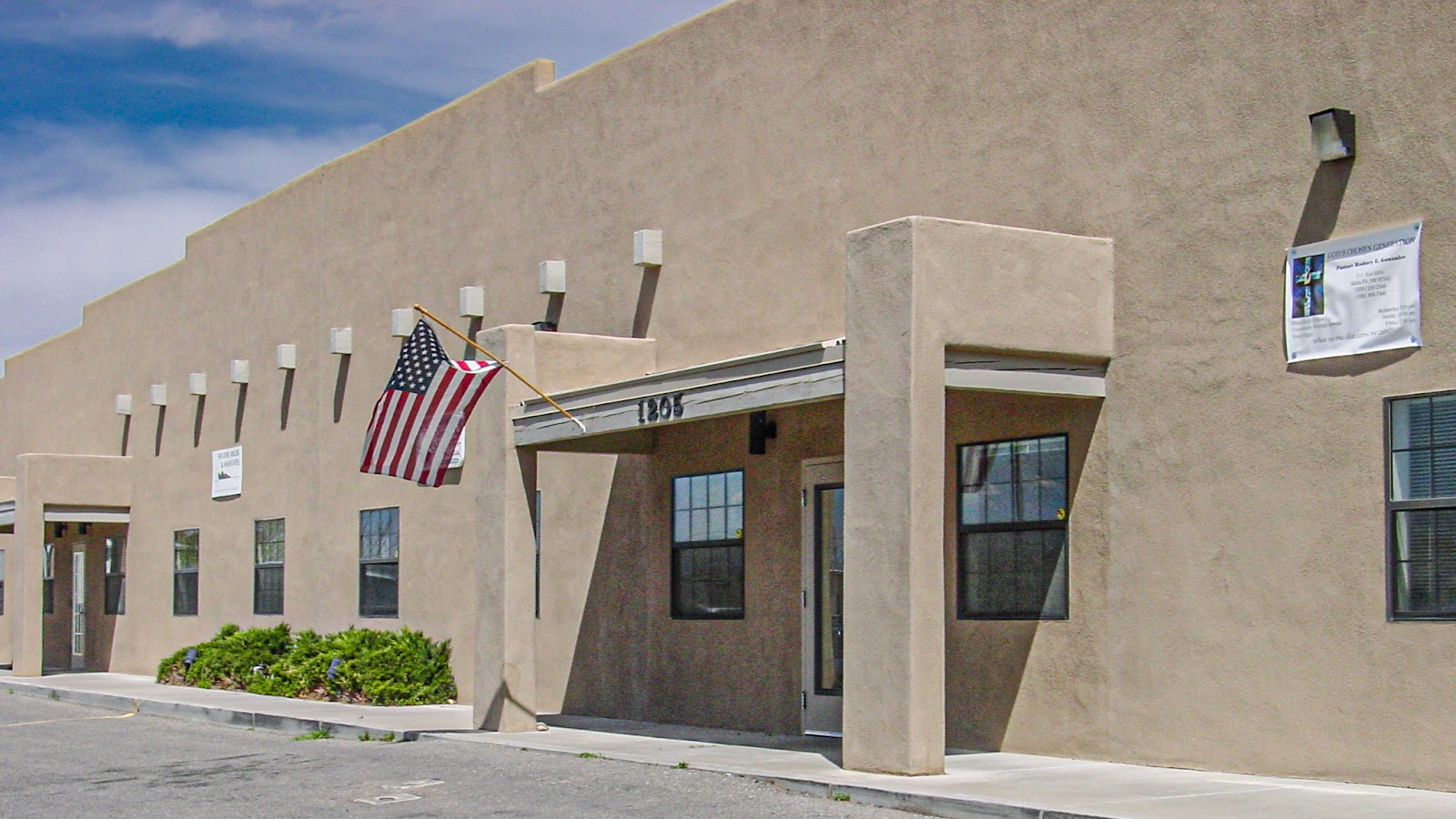 Adobe front building with a flag flying out front.