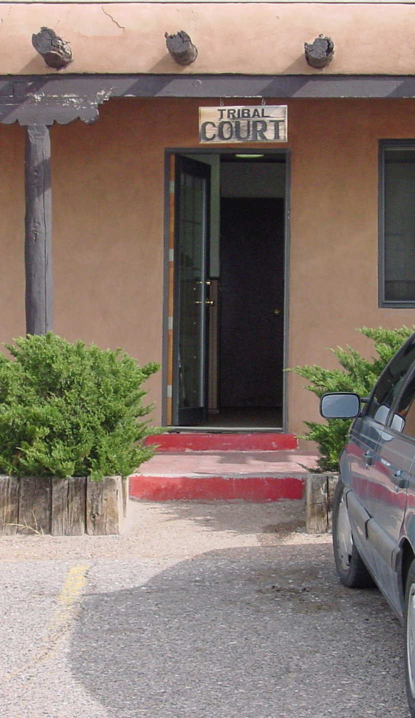 An open door has a sign above it that says: TRIBAL COURT. The door has two steps to get in. 