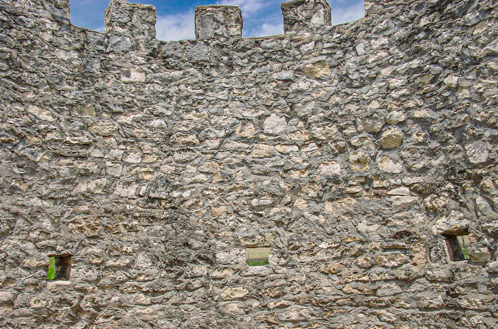 Inside a cylindrical turret of an old fieldstone structure showing small openings 