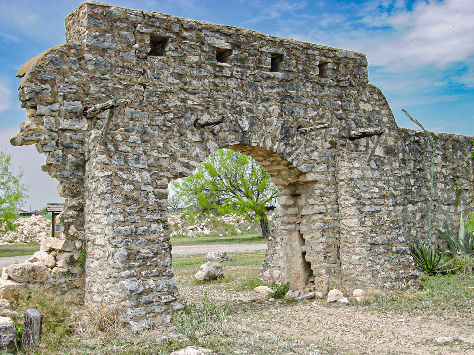 The ruins of an old fieldstone structure with an arched entrance and fallen walls. 