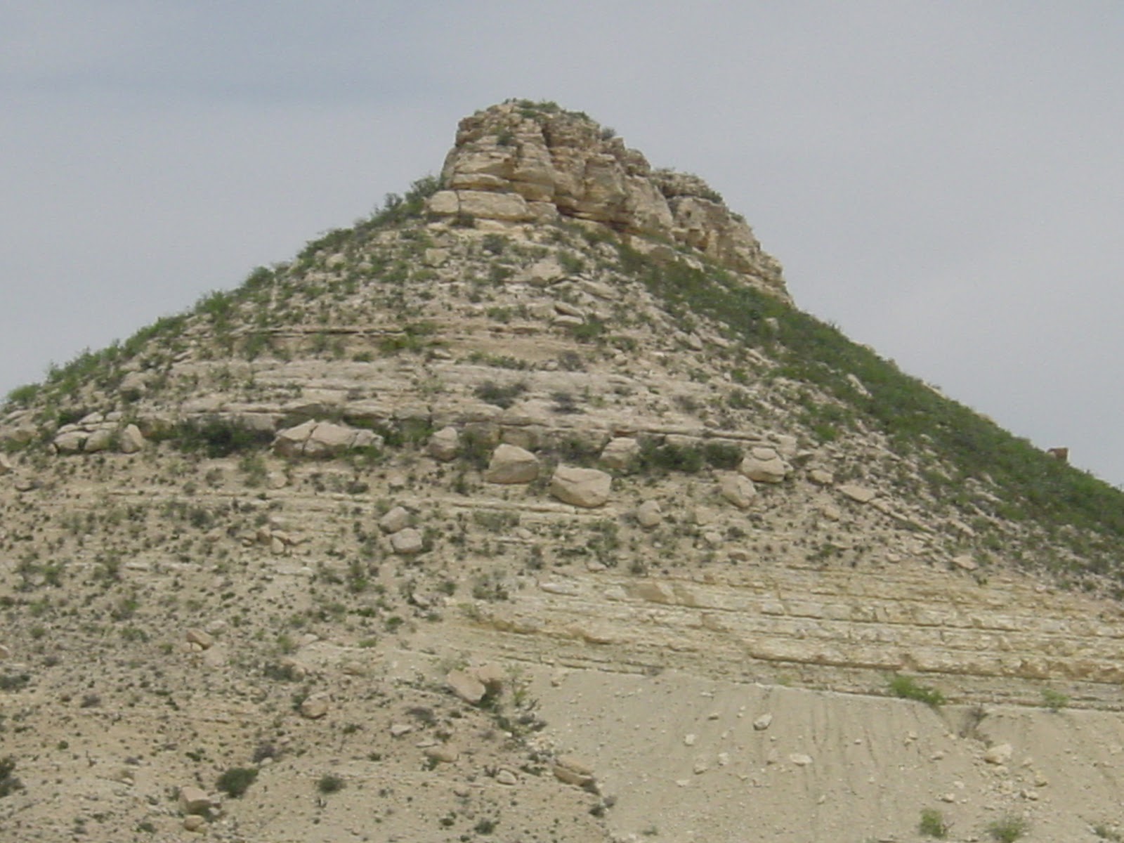 The top of a hill, with sandy dull surroundings