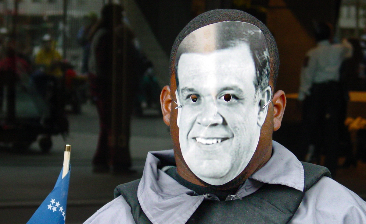 Man wears a mask over his face with only holes for his eyes. 