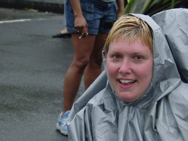 Woman in rain gear smiles wryly.