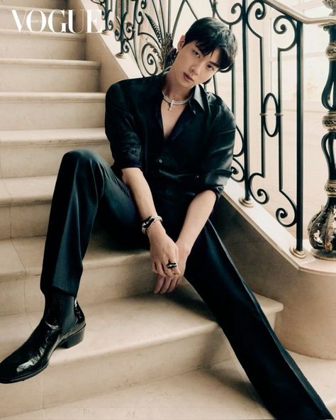  A picture of BTS's Jin putting black shirt,  trouser and shoe sitting in a stair case