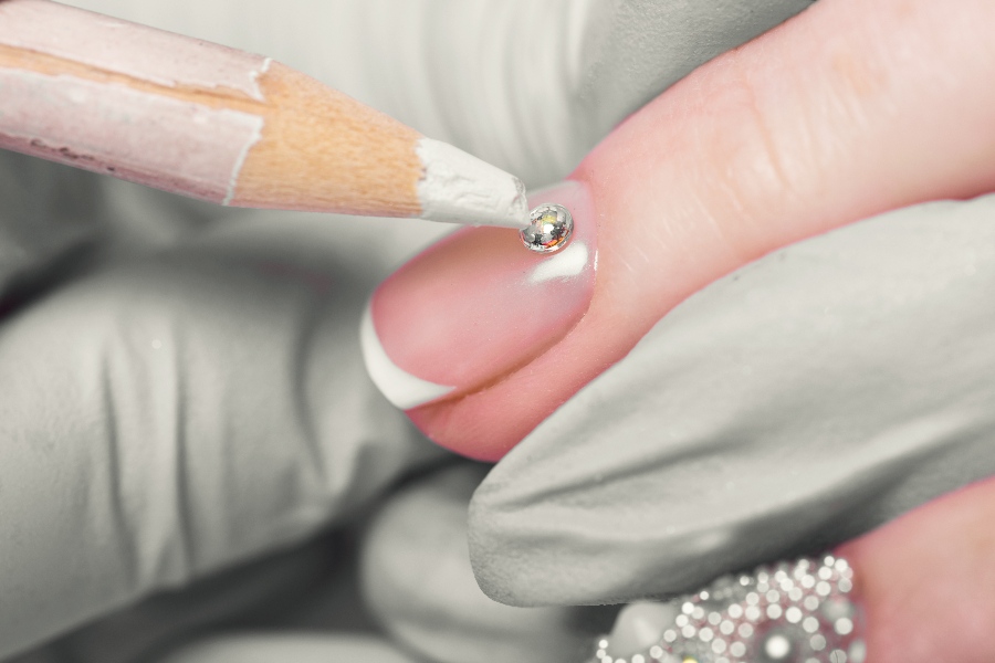 Pearl-studded tips add elegance and charm to classic French nail tip design.