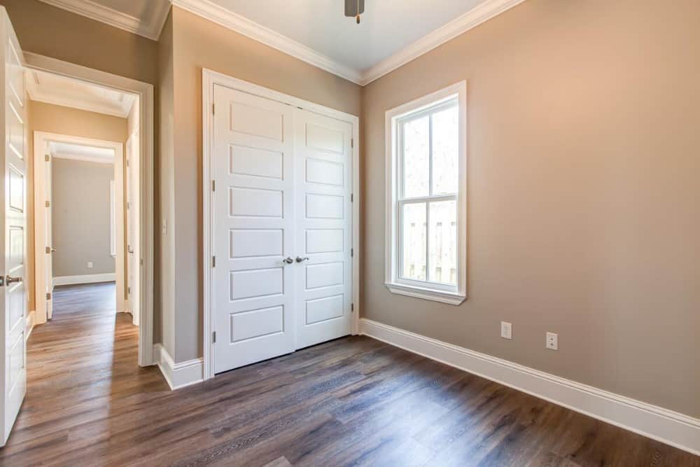 The bedroom includes a walk-in closet concealed behind the white double doors.