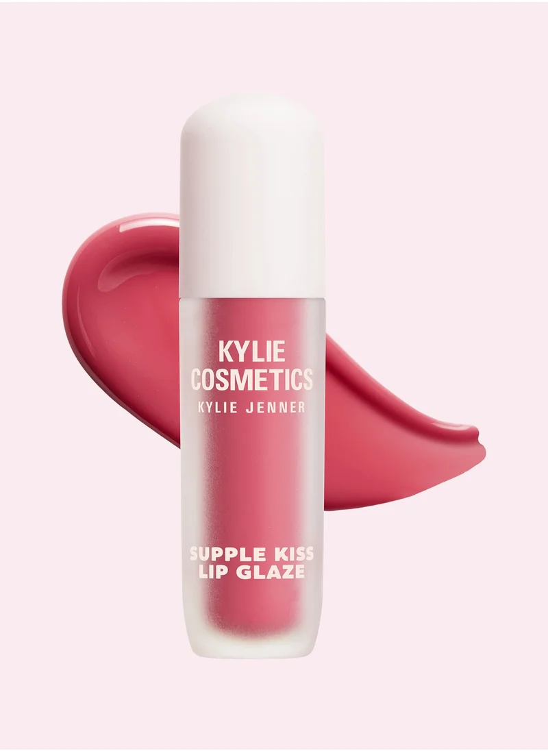 Frosted bottle of Kylie Supple Kiss Lip Glaze  lip balm for dry skin in pink with glossy swatch behind it.