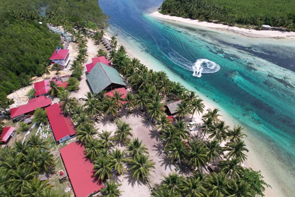 Tropical resort with palm trees, red roofs, and turquoise lagoon.