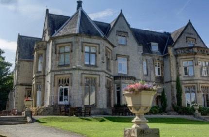 A large stone house with a large stone planter

Description automatically generated