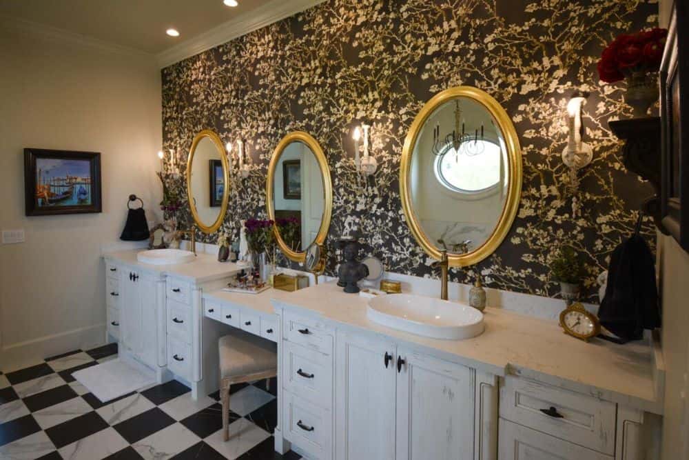 The primary bathroom offers double vanities and a makeup counter paired with round framed mirrors.