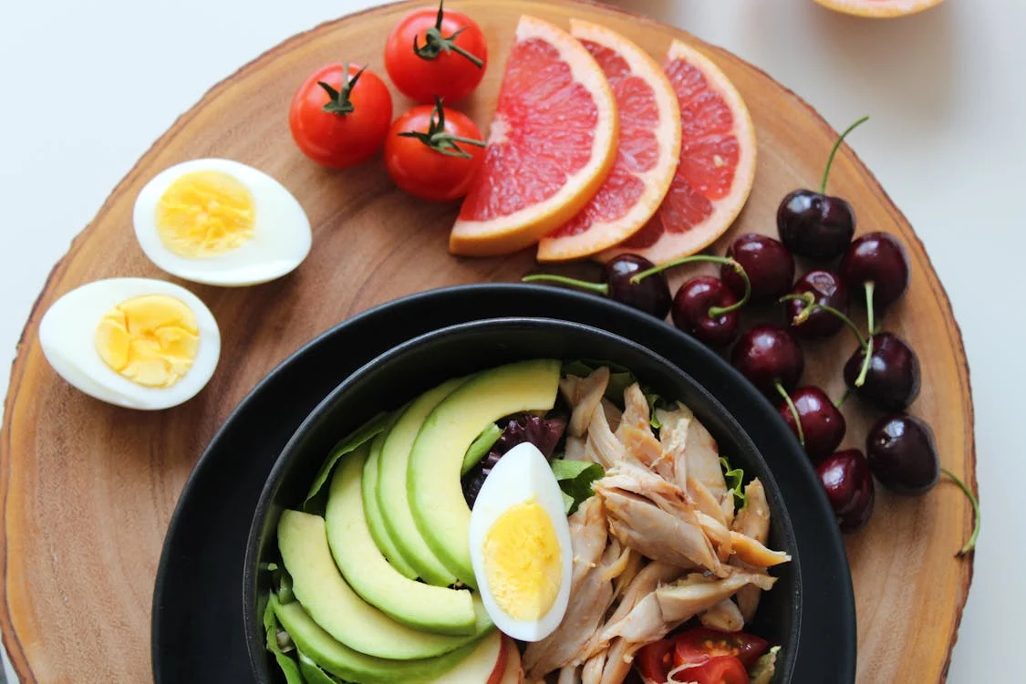 A bowl of healthy food, including eggs, chicken, and fruits. Healthy food choices can help you sleep better.