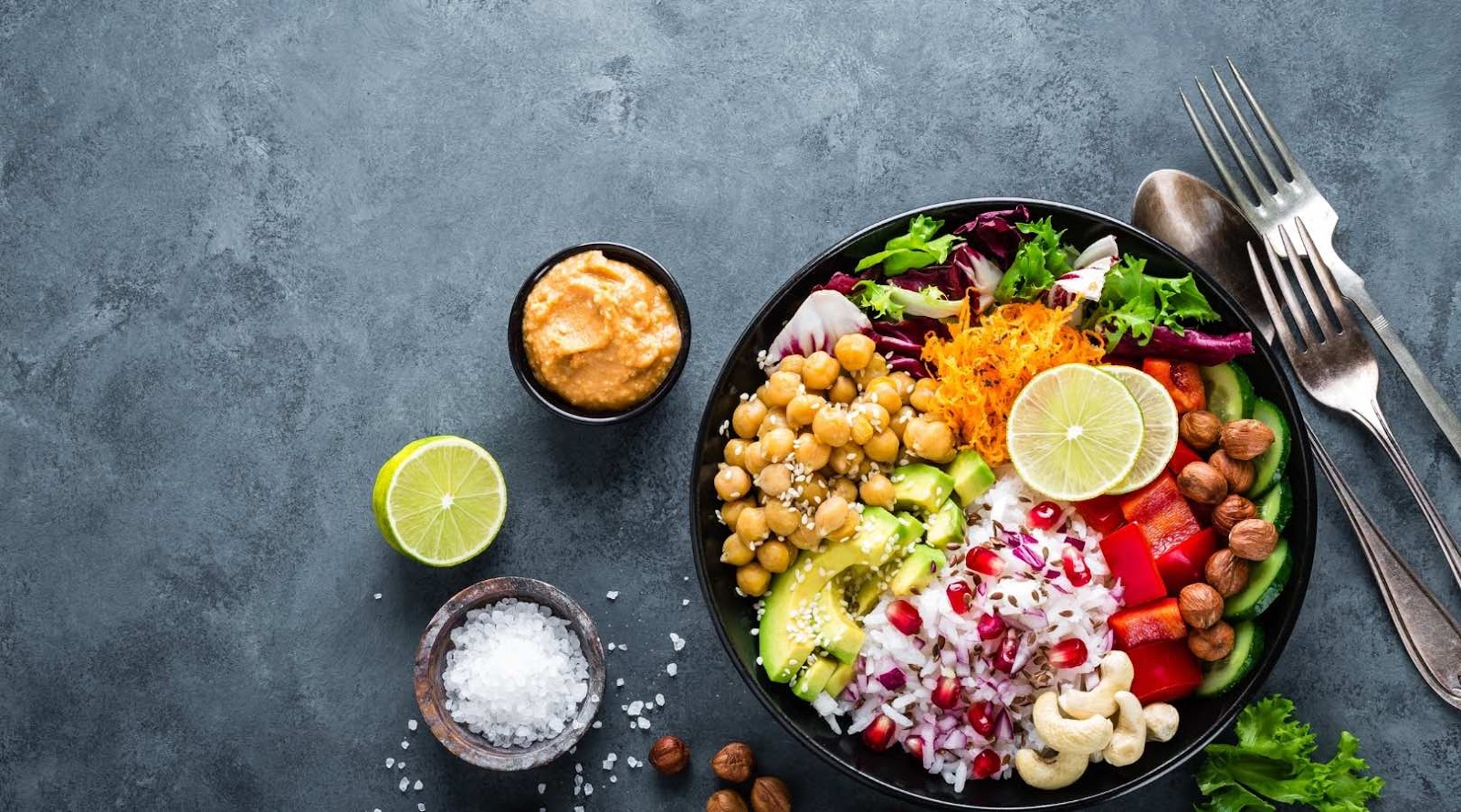 Un bol Bouddha santé avec des pois chiches, de l'avocat, de la grenade et des légumes variés, parfait pour un repas nutritif à Kanata.