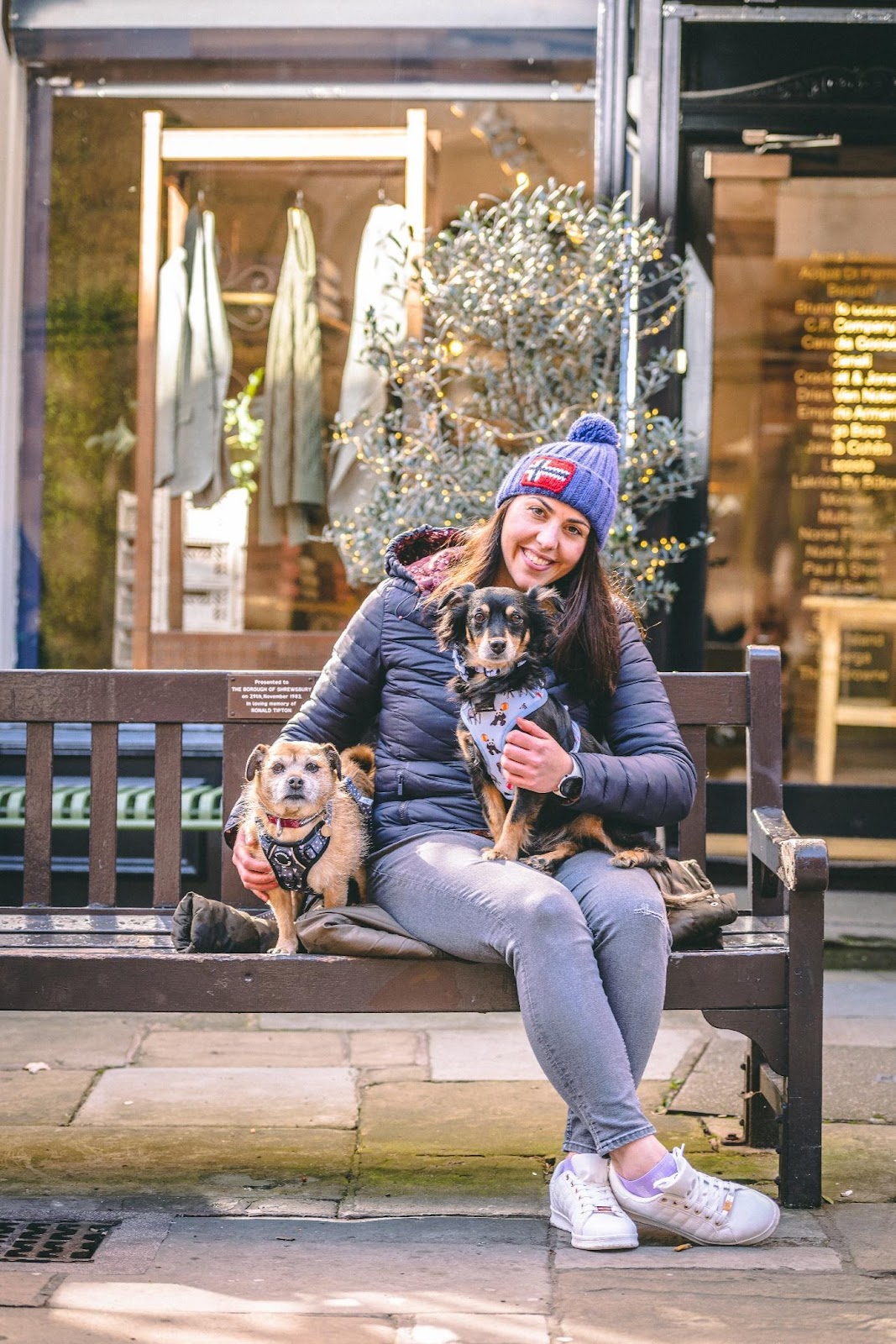 A person sitting on a bench with a dog

Description automatically generated