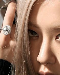 This contains an image of BLACKPINK's Rosé with a ring on her finger and hair in the background