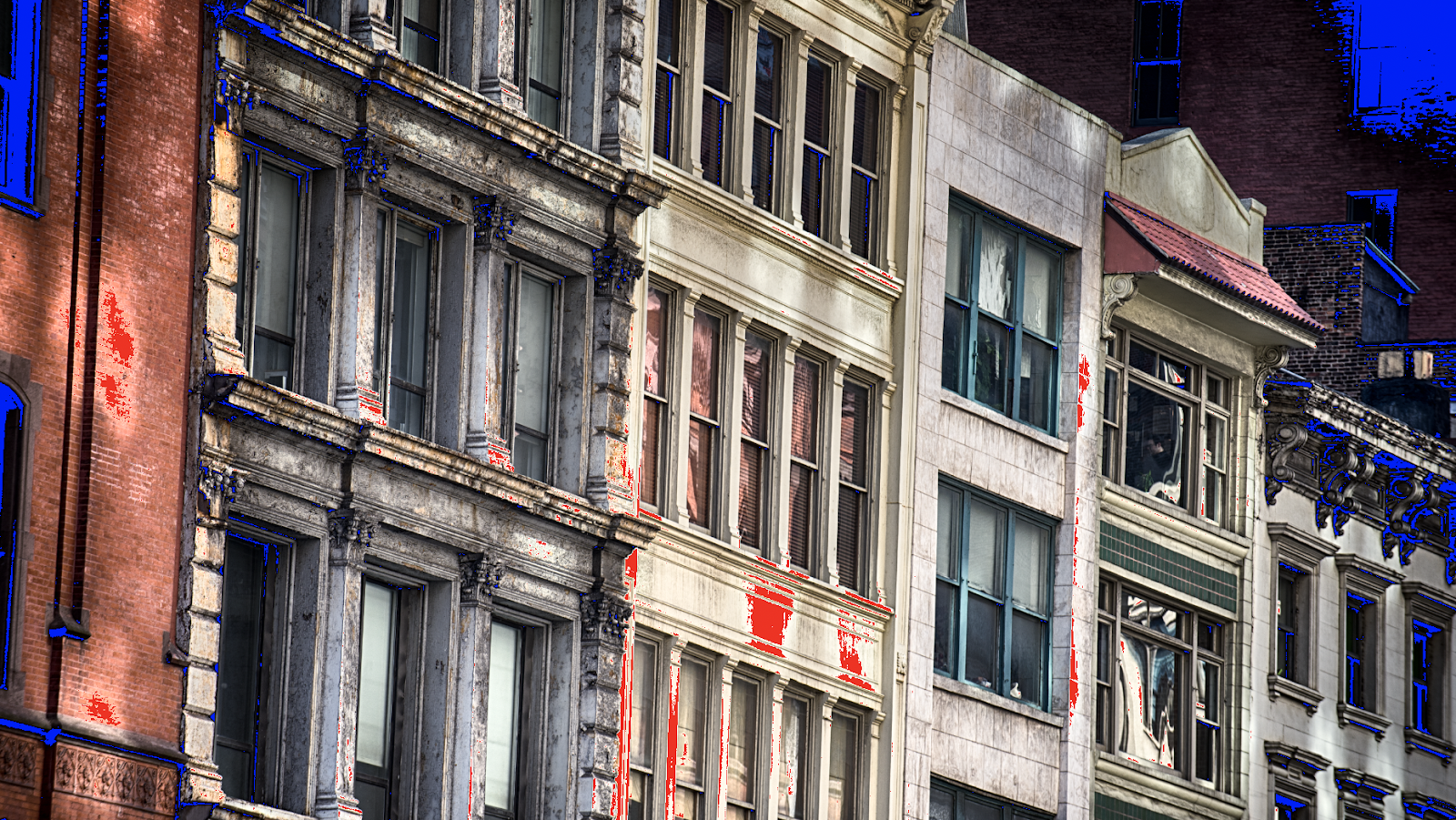 buildings on a street with red and blue shading in some areas