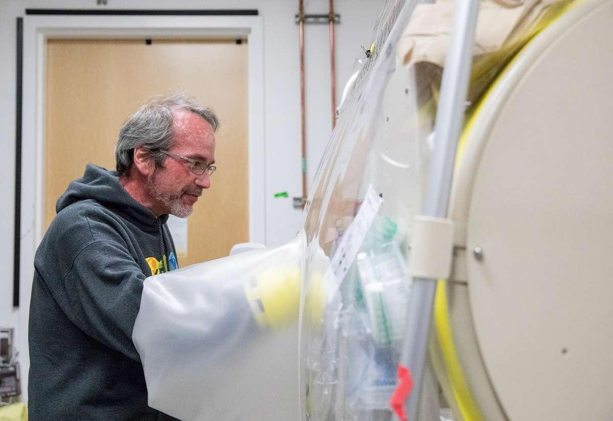 Image of Adam Arkin Head of CUBES and professor at UC Berkeley demonstrating work being done to find ways in which plants and other living organisms could be grown on future missions to the moon and Mars inside the NASA Center.