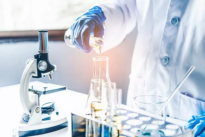 scientist-in-lab-coat-pouring-liquid-into-flask-with-microscope-and-test-tubes-on-laboratory-table-chonluten-and-peptides-stack-the-underground-combo-youve-been-missing-tony-huge
