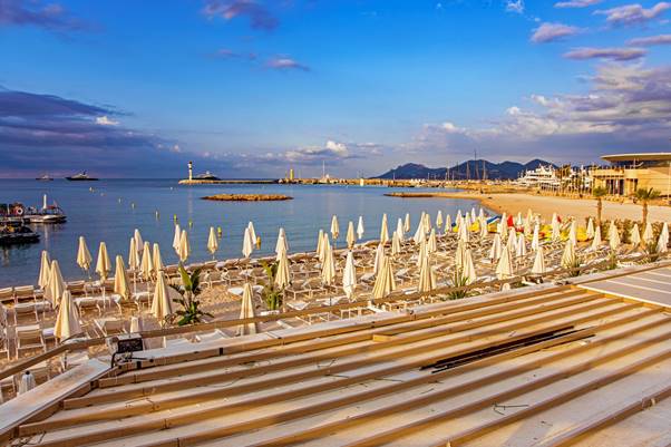 A Cannes beach with umbrellas and water

