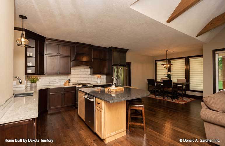 Just across the kitchen is the dining area placed near the three-paneled windows.