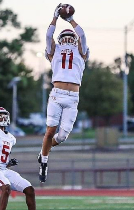 A football player jumping in the air

Description automatically generated