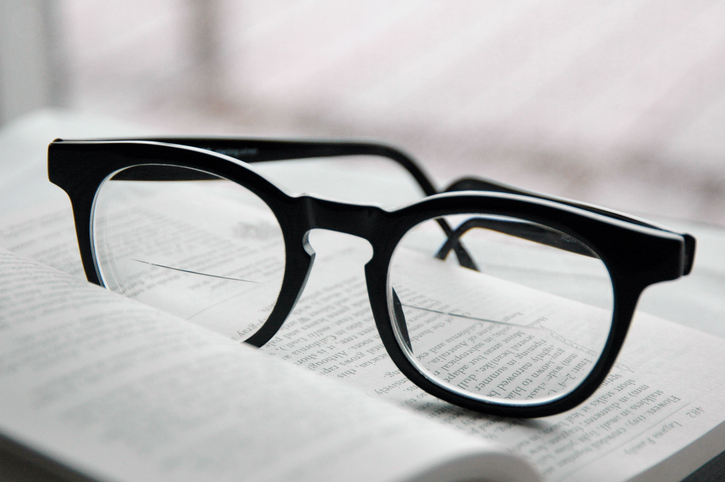 Close-up of a pair of bifocals sitting on an open book