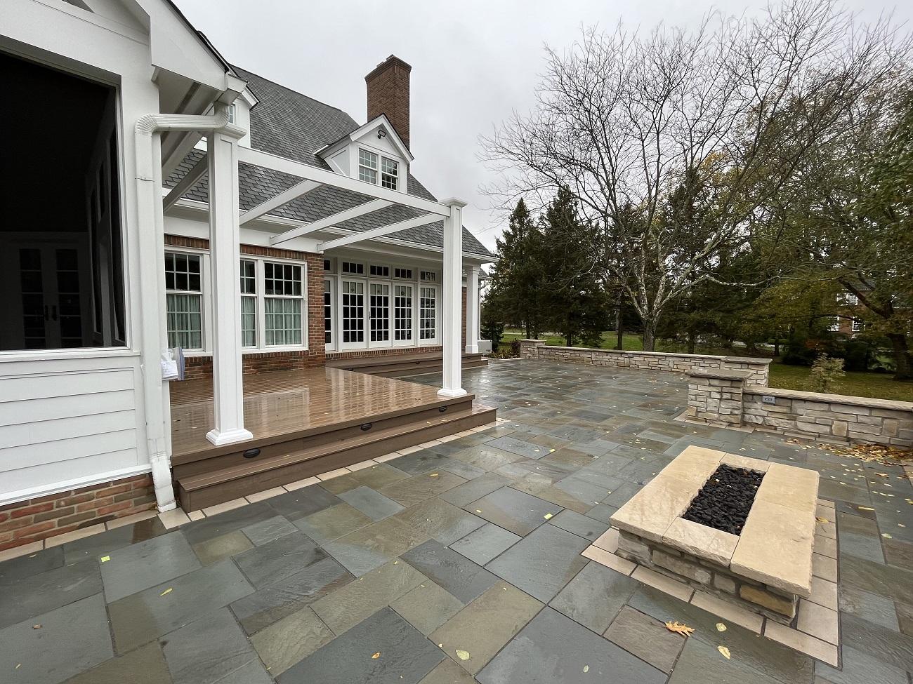 A stone patio with a fire pit and a porch

AI-generated content may be incorrect.