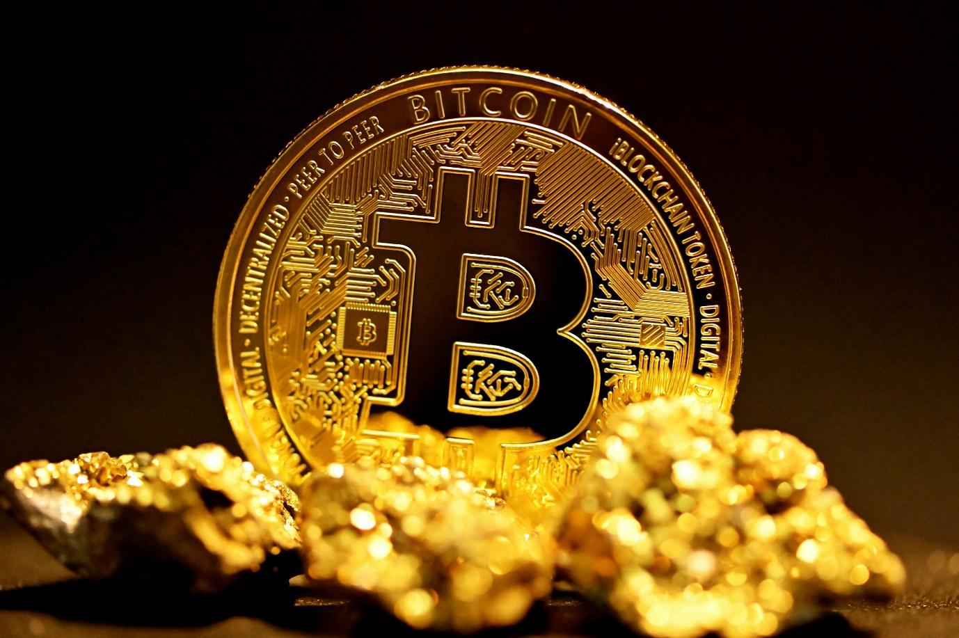 a bitcoin sitting on top of a pile of gold nuggets