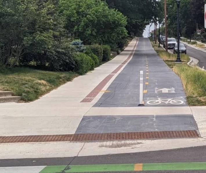 A bike path with trees and grass

AI-generated content may be incorrect.
