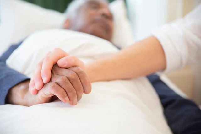 couple holding hands on hosptial bed