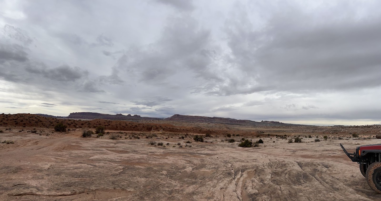 View of a Jeep heading up a 4x4 road toward dinosaur tracks.