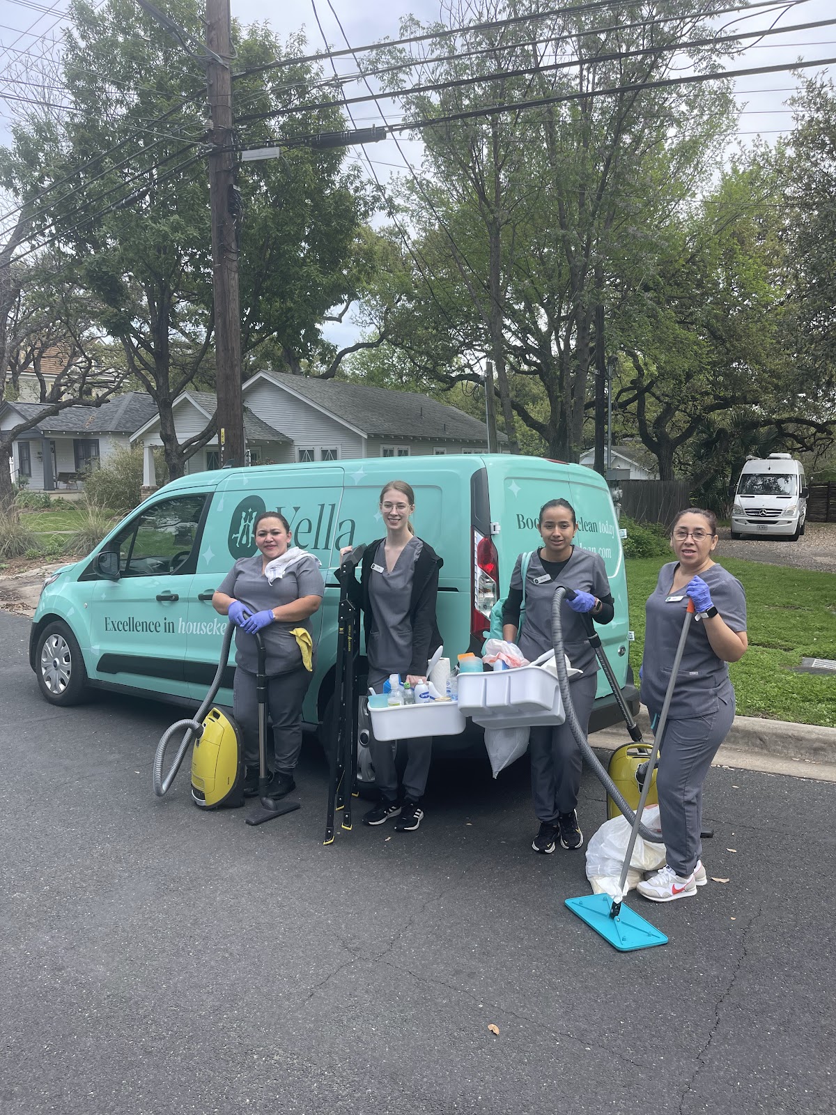 Eco-friendly cleaning team in Austin standing in front of a branded vehicle, equipped with sustainable cleaning supplies and tools for a greener approach.