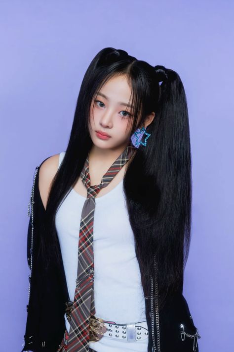 This contains an image of: Minji of NewJeans wearing a black jacket and a white singlet and a check knock tie 