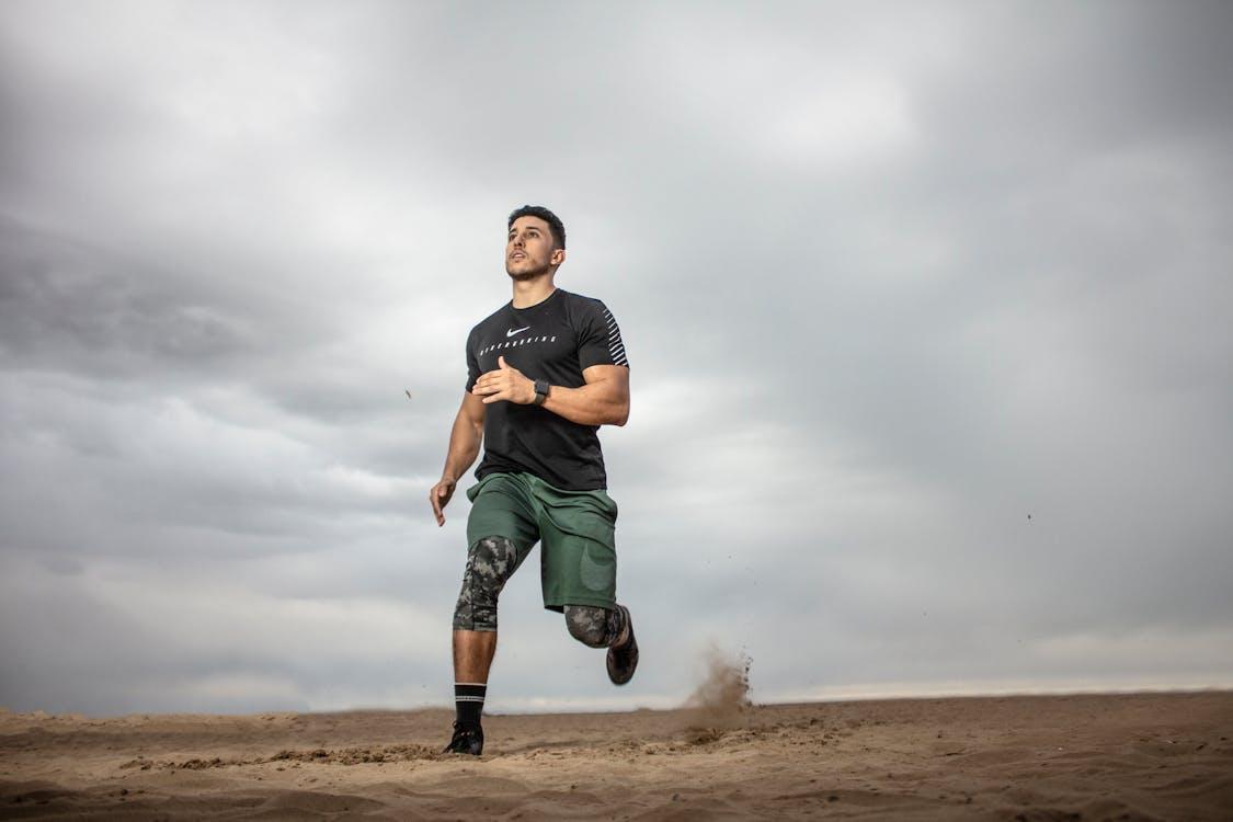 Free Man Running on Sand Field  Stock Photo