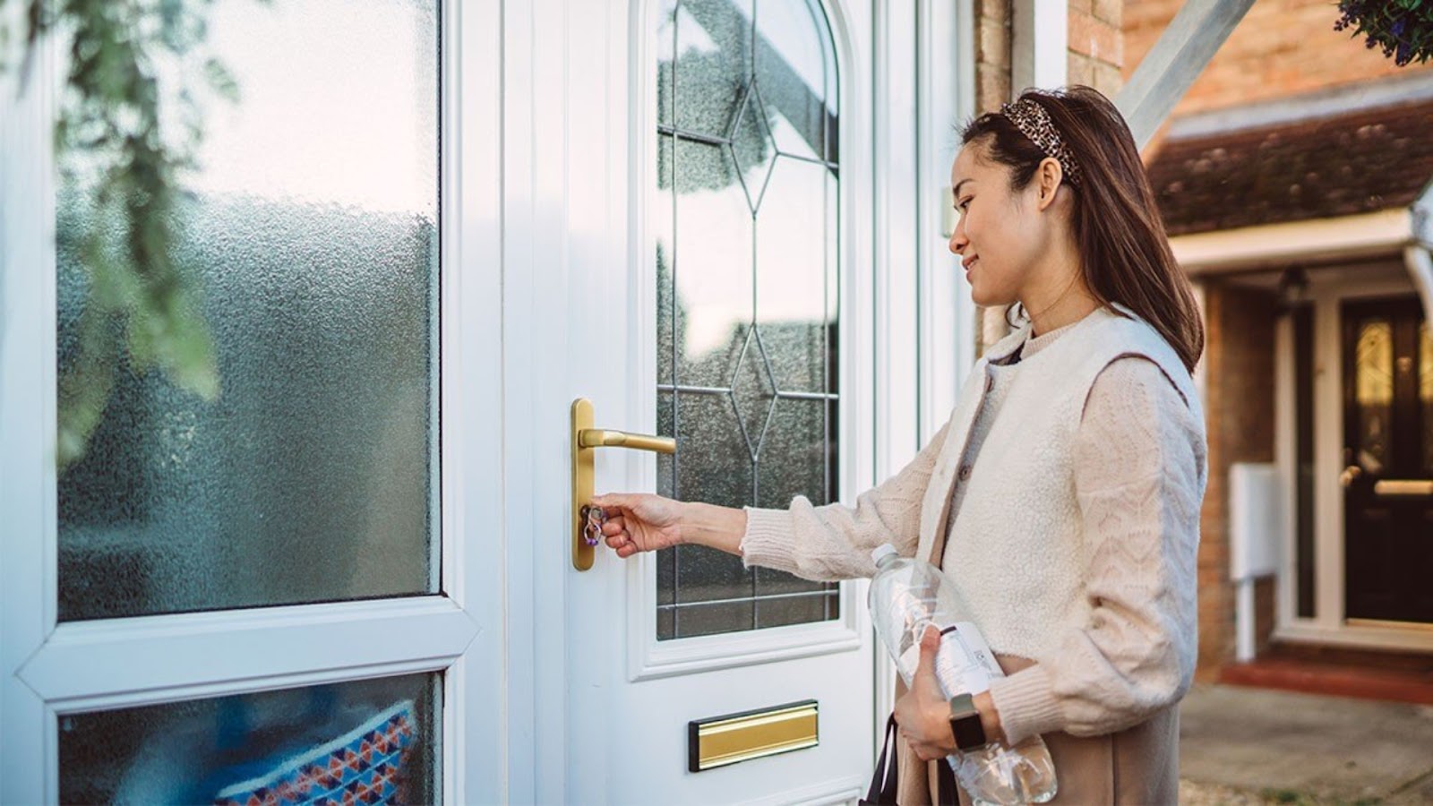 A woman locking the front door before leaving her home.