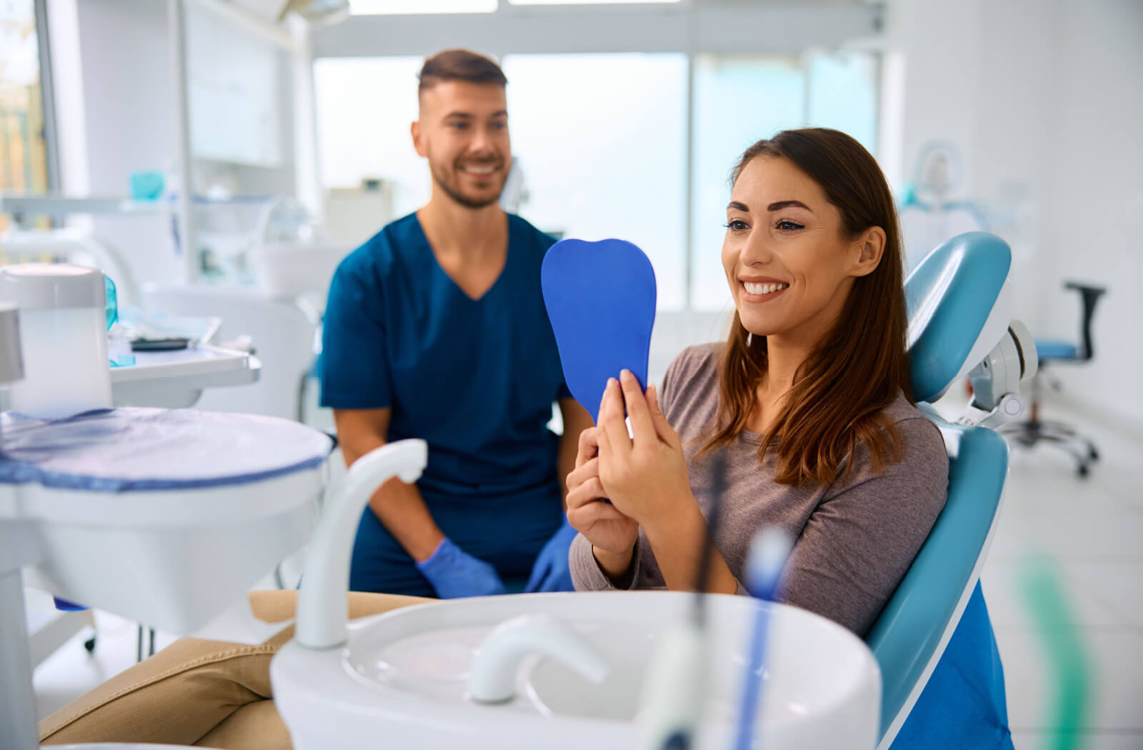 A patient smiling after a dental exam to install their new dental implant.
