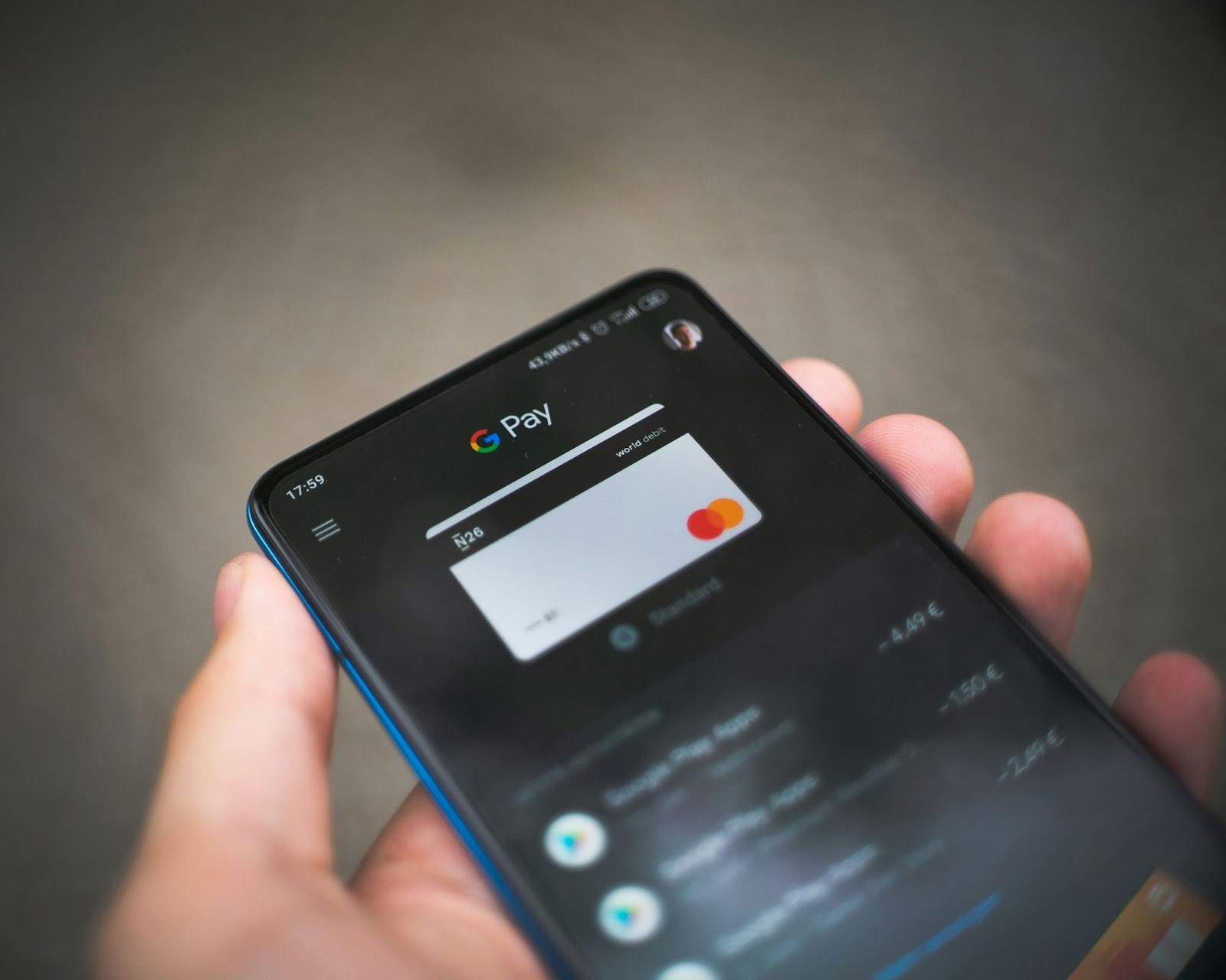 Close-up of a smartphone displaying the G Pay app with transaction details on the screen