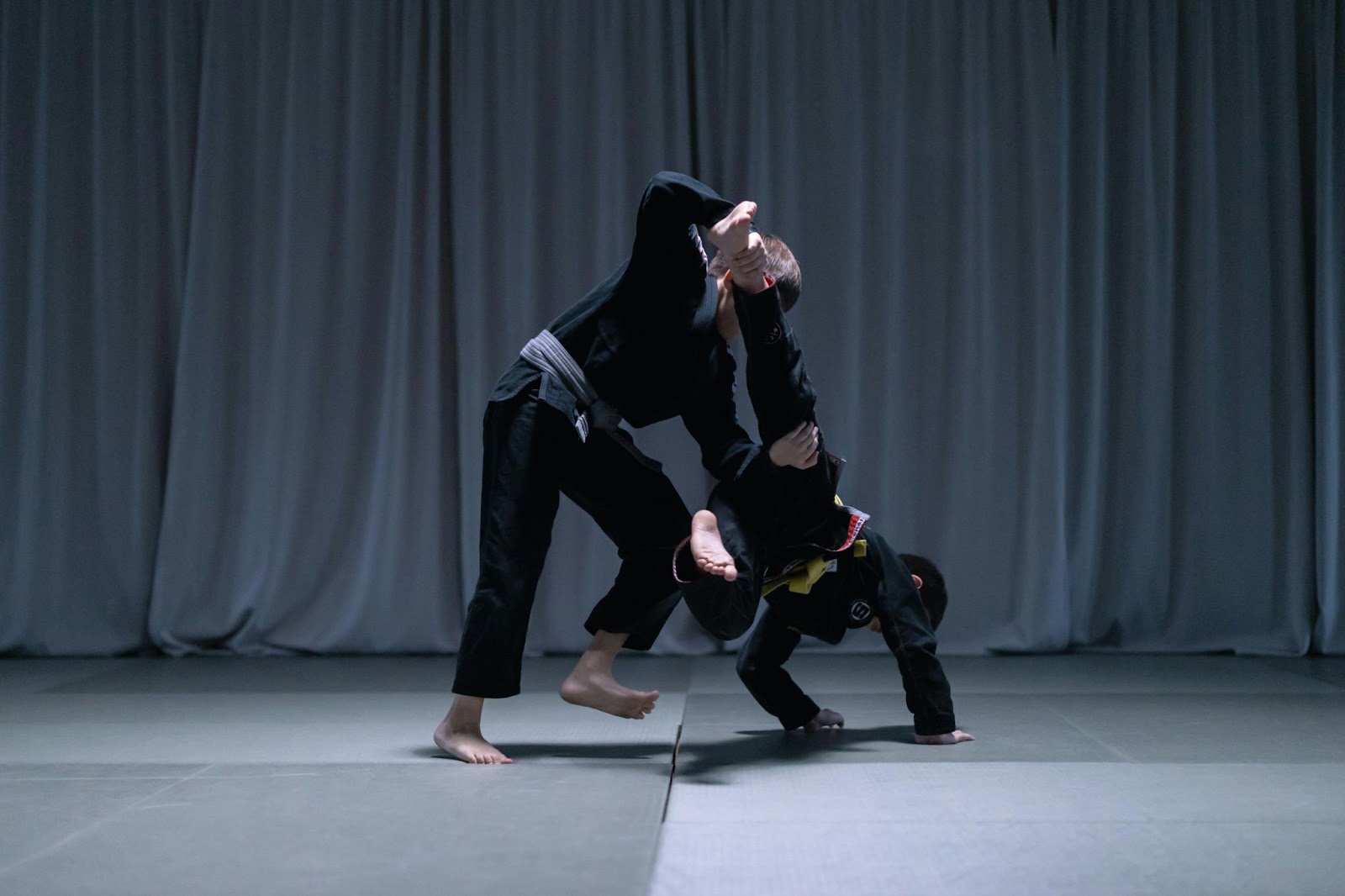 Two martial arts students practicing leg sweeps