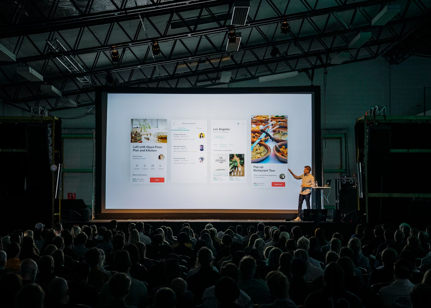 https://unsplash.com/photos/person-discussing-while-standing-in-front-of-a-large-screen-in-front-of-people-inside-dim-lighted-room-bzdhc5b3Bxs