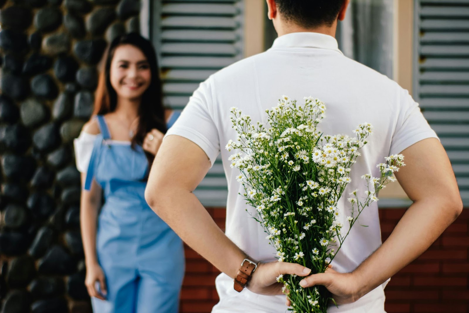 A man surprising his wife with a flower